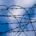 Barbed Wire in the shape of a heart, with blue sky in the background